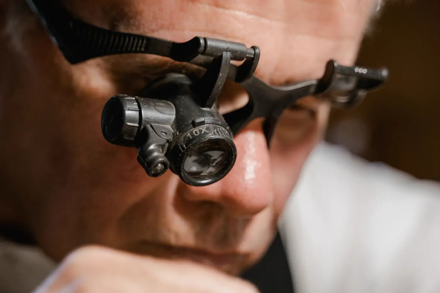 Close-up of a craftsman wearing an eye loupe for precision work