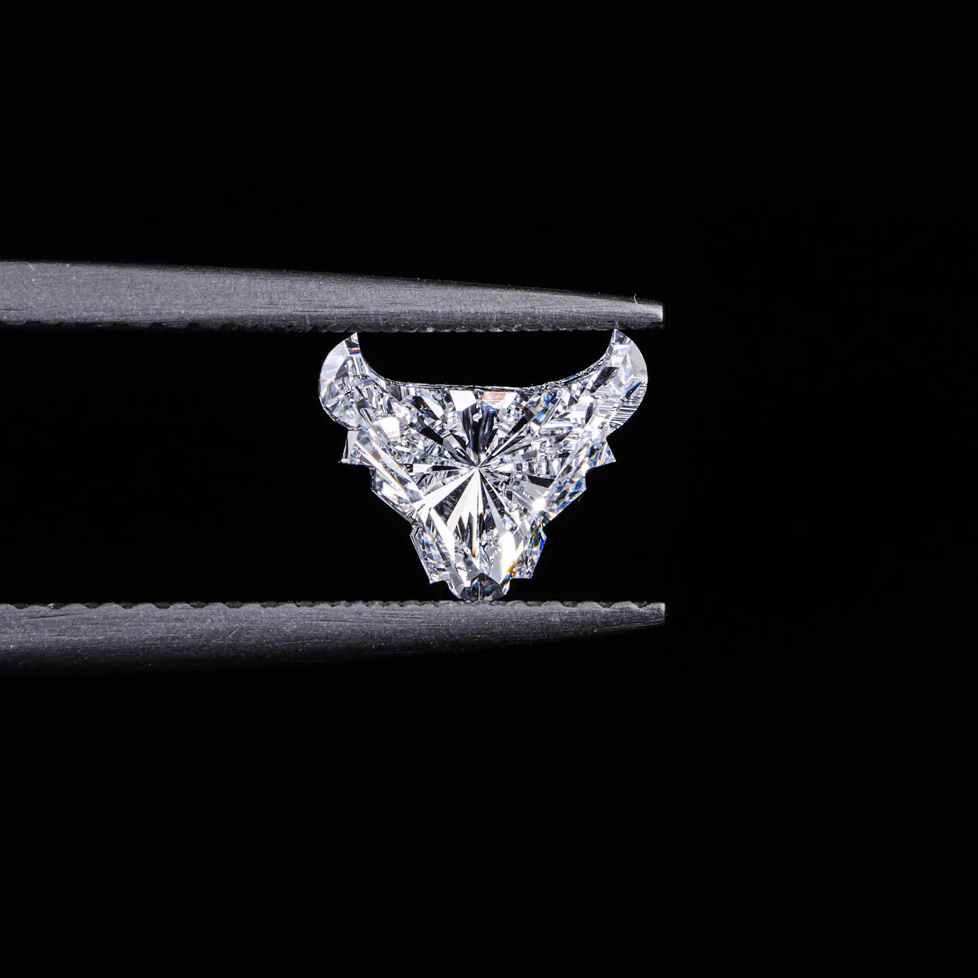 A lab-grown bull cut diamond showing its brilliance against a dark background